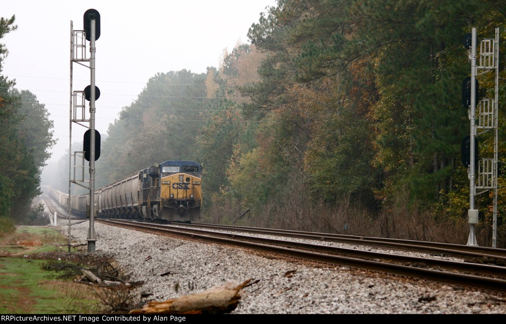 CSX 117 and 5465 wait for green with a line of covered hoppers at the N.E. Aberdeen signals